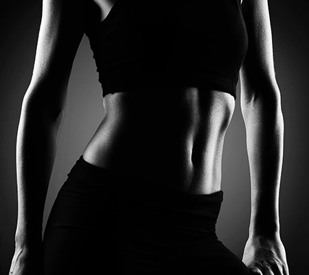 Image of a woman wearing black top and pants after adomen liposuction